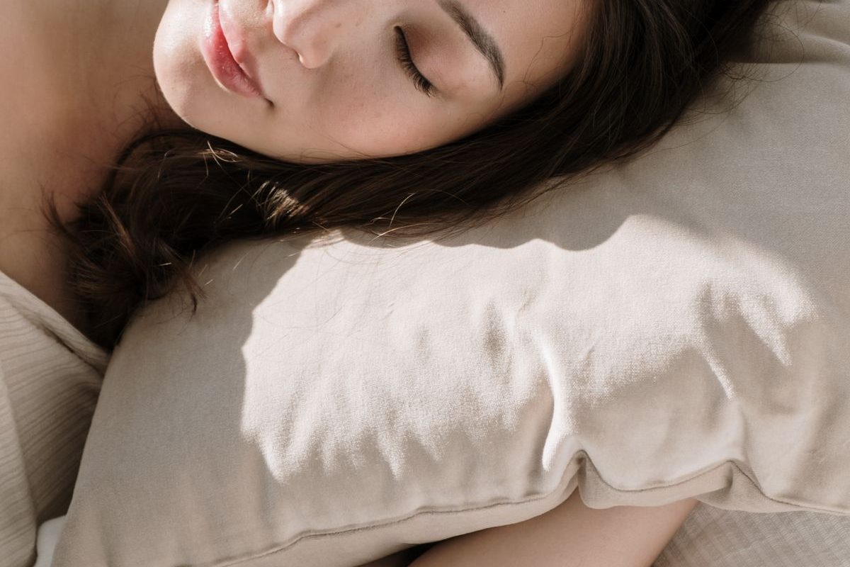 A woman sleeping peacefully in soft morning light — homeopathy for sleep problems in Ontario, CA