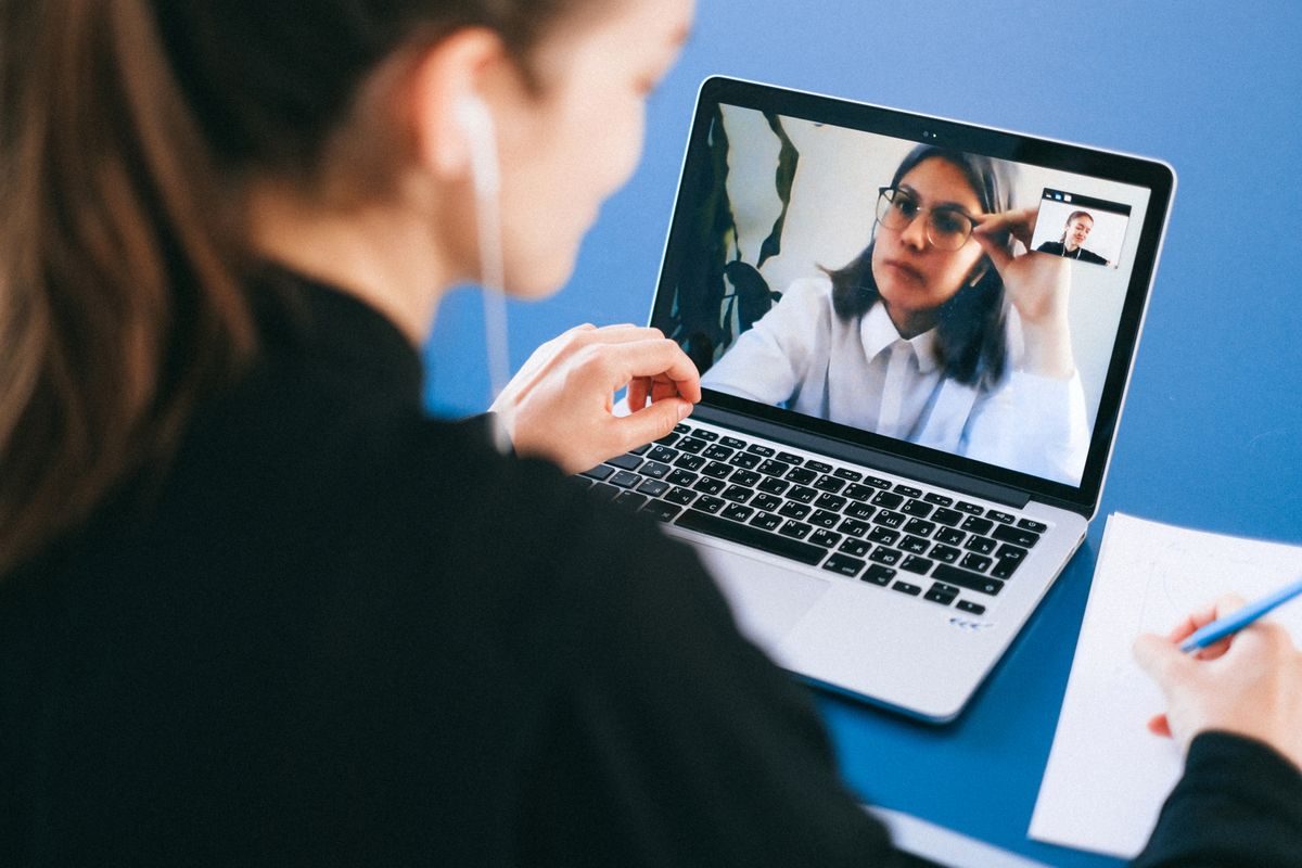 A woman on a video call with her homeopath on a laptop — virtual homeopathy consultation